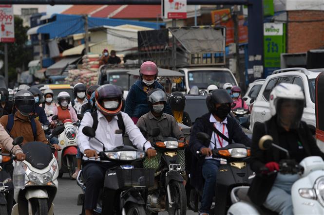 Người dân di chuyển trên đường phố thủ đô Phnom Penh, Campuchia ngày 26-8-2021. Ảnh: AFP/TTXVN