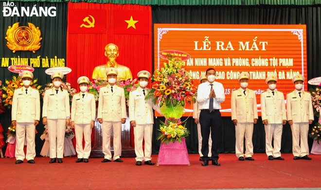 Chủ tịch UBND thành phố Lê Trung Chinh (thứ 4, trái sang) tặng hoa chúc mừng tập thể Phòng An ninh mạng và phòng, chống tội phạm công nghệ cao, Công anh thành phố. Ảnh: LÊ HÙNG