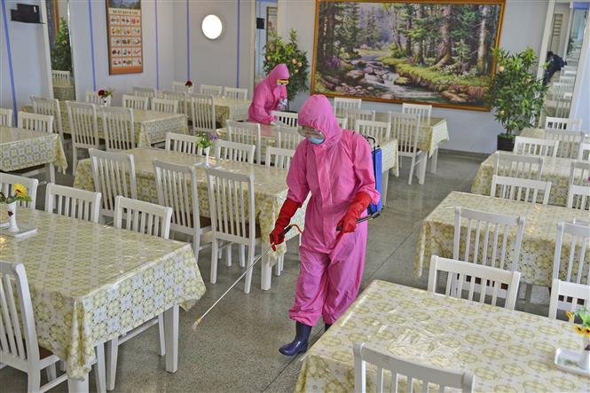 Phun thuốc khử trùng nhằm ngăn chặn sự lây lan của Covid-19 tại nhà ăn của một nhà máy ở Bình Nhưỡng, Triều Tiên, ngày 16-5-2022. Ảnh: Kyodo/TTXVN