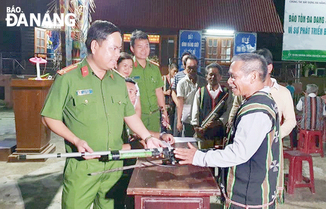 Trung tá Lê Văn Tư (bên trái) cùng lực lượng Công an xã Hòa Bắc tiếp nhận vũ khí, công cụ hỗ trợ do người dân tự nguyện giao nộp. Ảnh: TRÍ DŨNG