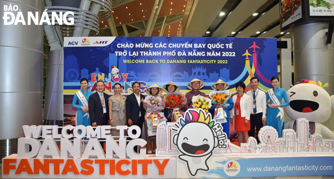 Phó Giám đốc Sở Du lịch Nguyễn Xuân Bình cùng đại diện các đơn vị liên quan tặng hoa, chào đón những vị khách trên chuyến bay đầu tiên từ Incheon (Hàn Quốc) đến Đà Nẵng. Ảnh: THU HÀ.