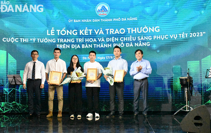 Giám đốc Sở Xây dựng Phùng Phú Phong (bên trái) và Giám đốc Sở Tài nguyên và Môi trường Tô Văn Hùng (bên phải) trao giải nhất cho các nhóm tác giải về ý tưởng trang trí hoa, ý tưởng trang trí điện chiếu sáng phục vụ Tết Quý Mão 2023. 
