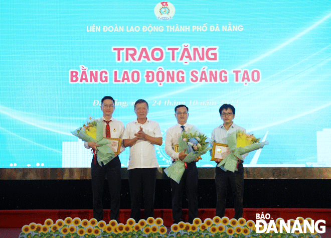 Trưởng ban Dân vận Thành ủy Lê Văn Trung (thứ 2, bên trái sang) trao bằng Lao động sáng tạo của Tổng Liên đoàn Lao động Việt Nam cho 3 đoàn viên có nhiều sáng kiến, sáng tạo. Ảnh: LAM PHƯƠNG	