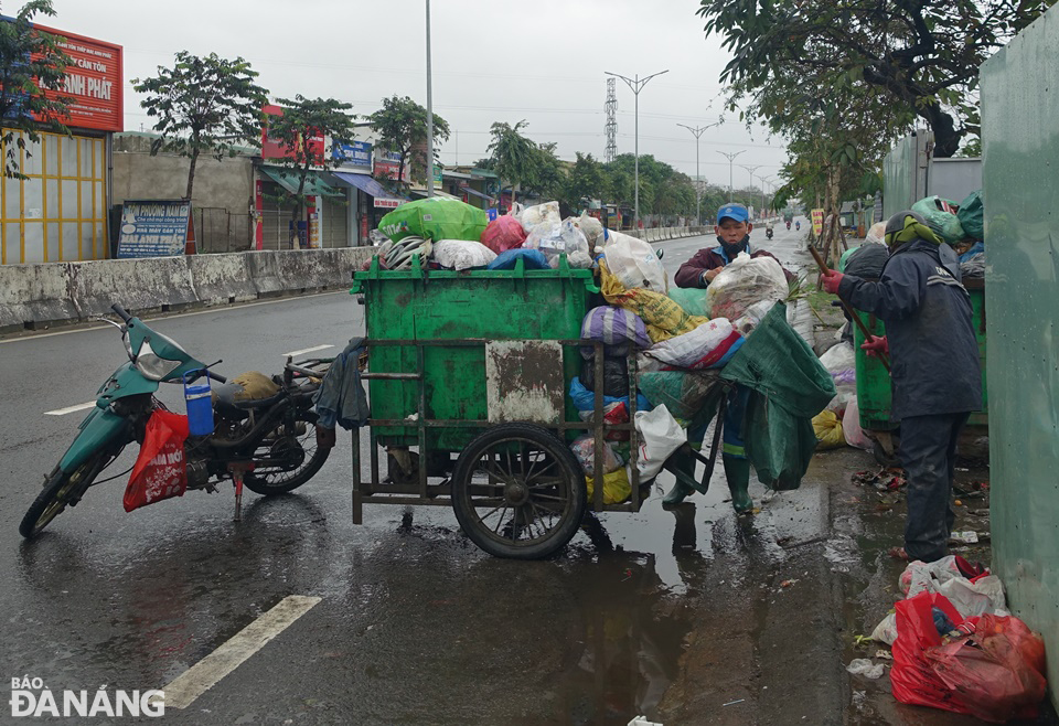 Khối lượng rác sinh hoạt phát sinh trên đường phố rất lớn. Trong ảnh: Công nhân của URENCO 15 đưa rác về một điểm tập kết trên đường Hoàng Văn Thái.