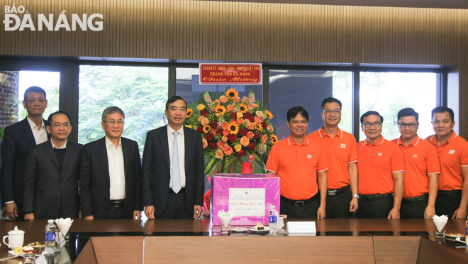 Chủ tịch UBND thành phố Lê Trung Chinh (thứ 3, từ trái sang) tặng quà, động viên cán bộ, nhân viên Tập đoàn FPT. Ảnh: MAI QUẾ