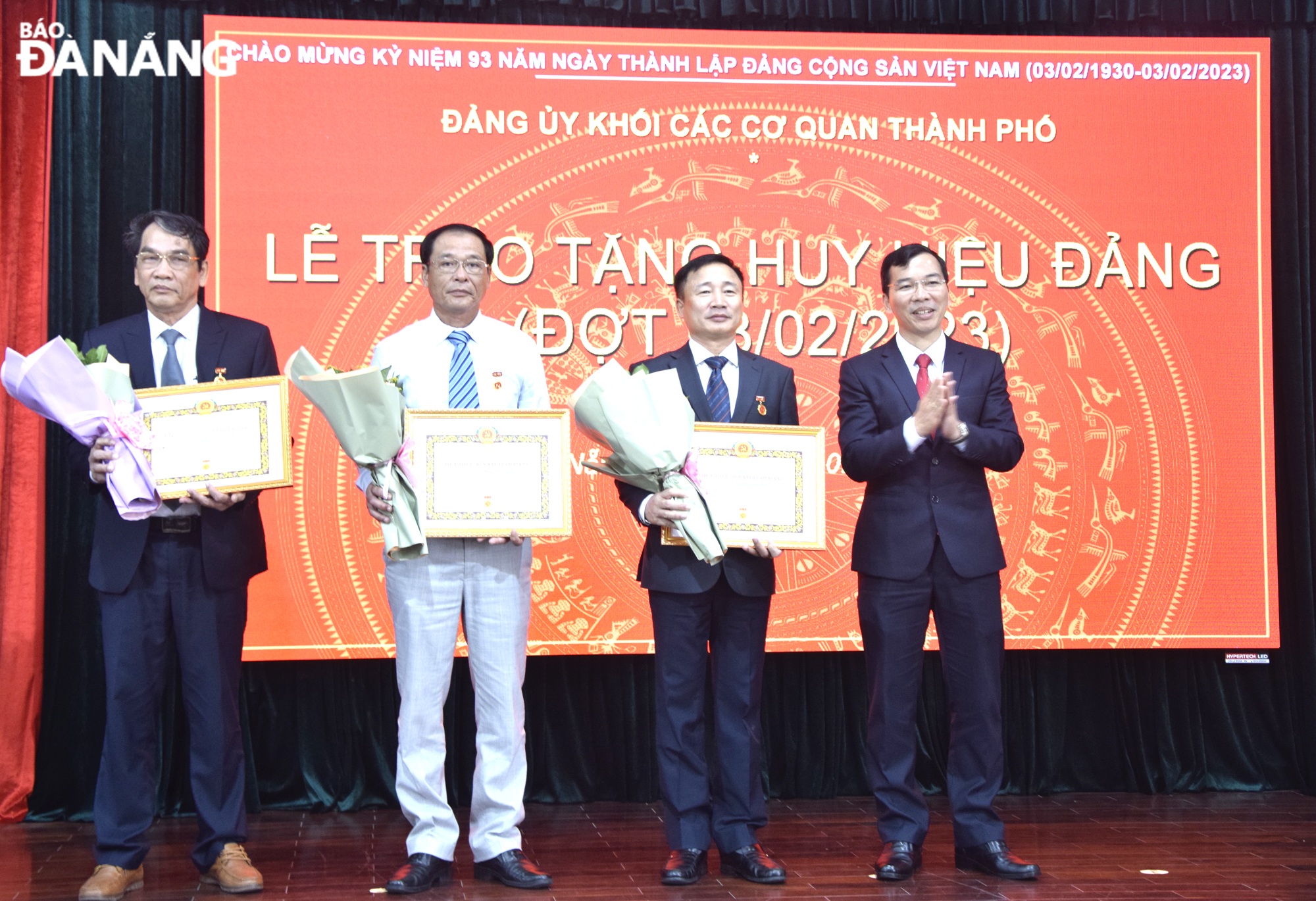 Bí thư Đảng ủy Khối các cơ quan thành phố Nguyễn Hữu Lợi (bìa phải) trao Huy hiệu Đảng và chúc mừng các đảng viên đủ tiêu chuẩn. Ảnh: T. HUY