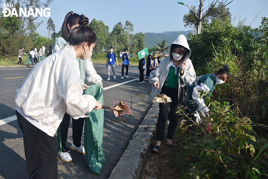 Các tình nguyện viên chia nhau thu gom rác tại các khu vực ngã ba Lê Văn Lương - Hồ Xanh - Chùa Linh Ứng... Ảnh: THU HÀ