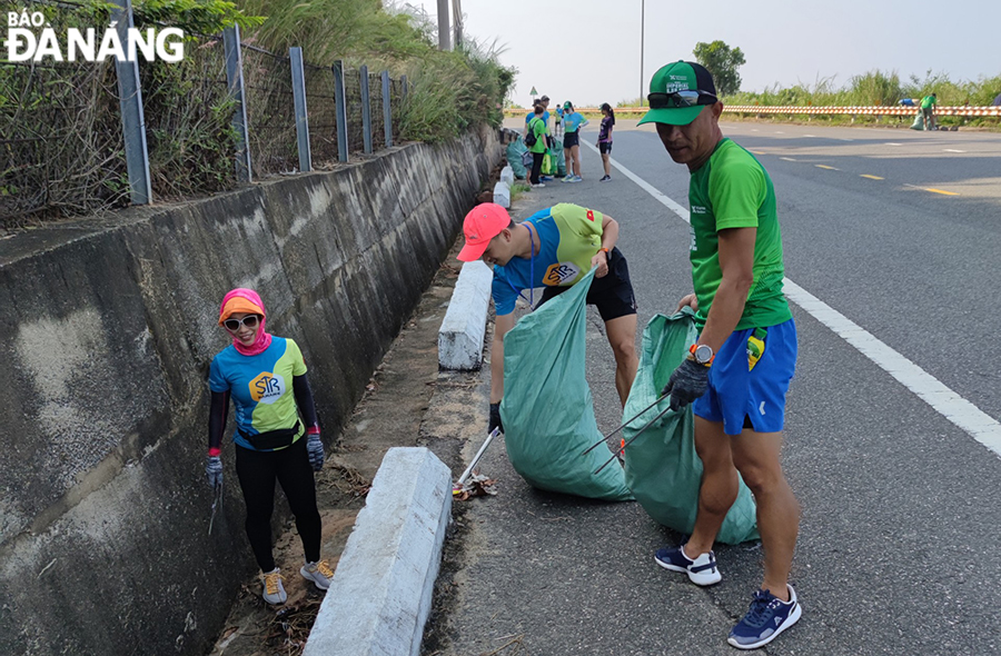 Các thành viên của câu lạc bộ chạy bộ Son Tra Runners tham gia thu gom rác tuyến đường lên chùa Linh Ứng. Ảnh: THU HÀ