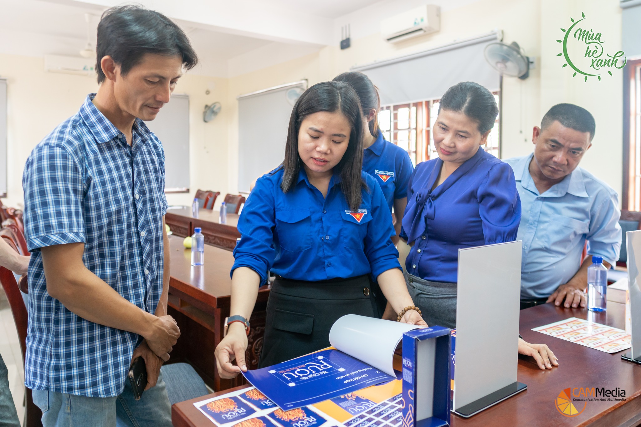 Ông Phan Văn Hùng (ngoài cùng, bên trái) đang được nhóm sinh viên chia sẻ thông tin về bao bì nhận diện thương hiệu rượu đông trùng hạ thảo Quỳnh Tâm. Ảnh: H.L	