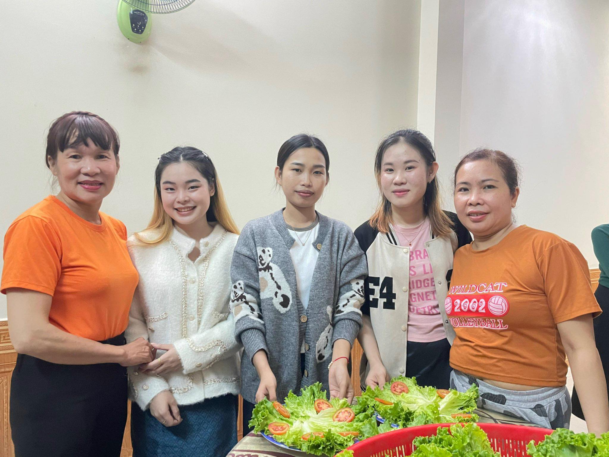 Sisavengsouk Douang (giữa) và các bạn cùng mẹ Thành nấu ăn. Ảnh: NVCC