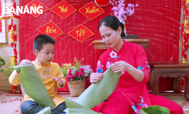 Các bé Trường Mầm non Hồng Nhung (quận Thanh Khê) trải nghiệm gói bánh chưng tại lễ hội mùa xuân do nhà trường tổ chức. Ảnh: NGỌC HÀ