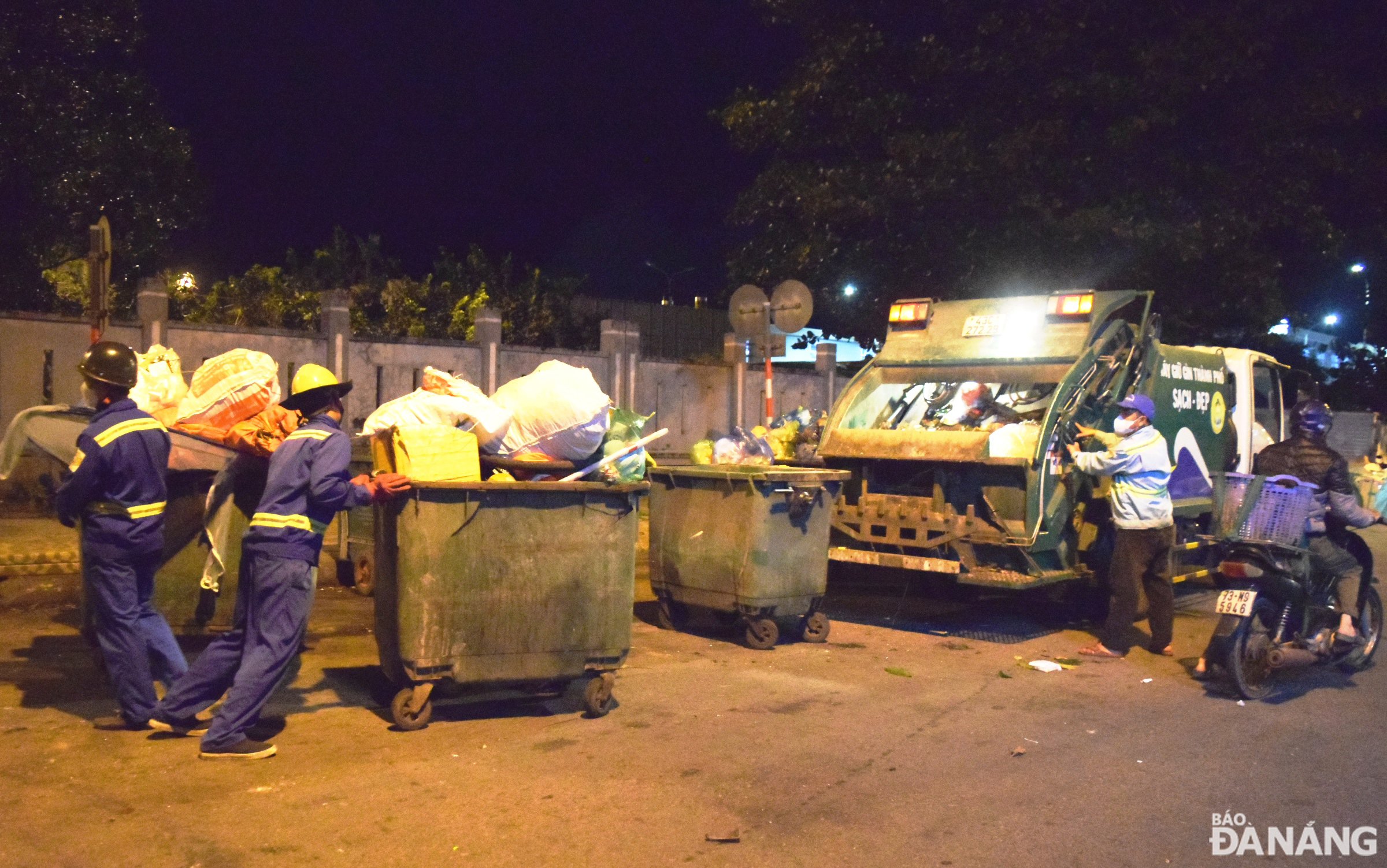 Các công nhân Xí nghiệp Môi trường Sơn Trà đang khẩn trương thu gom rác trong đêm giao thừa. Ảnh: HOÀNG HIỆP