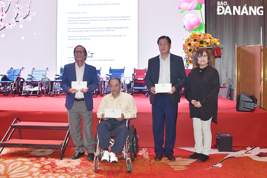 Representative of the Japan Foundation for Social Contribution Fund (right) donate wheelchairs to 3 units in Da Nang, March 3, 2024. Photo: THU HA
