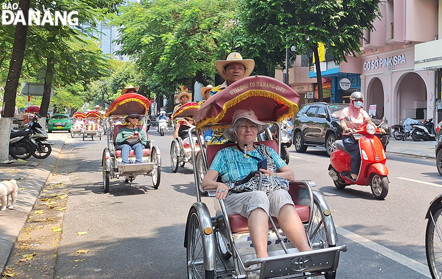 Foreign visitors taking a cyclo tour in Da Nang. Photo: THU HA