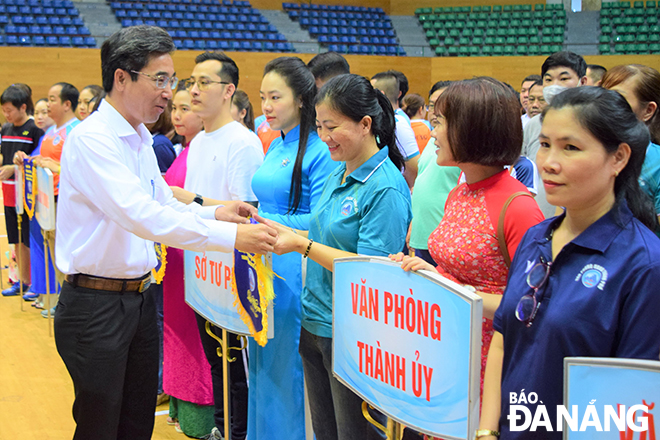 Phó Chủ tịch UBND thành phố Trần Chí Cường (bên trái) tặng cờ lưu niệm cho các đơn vị dự hội thi. Ảnh: T.D
