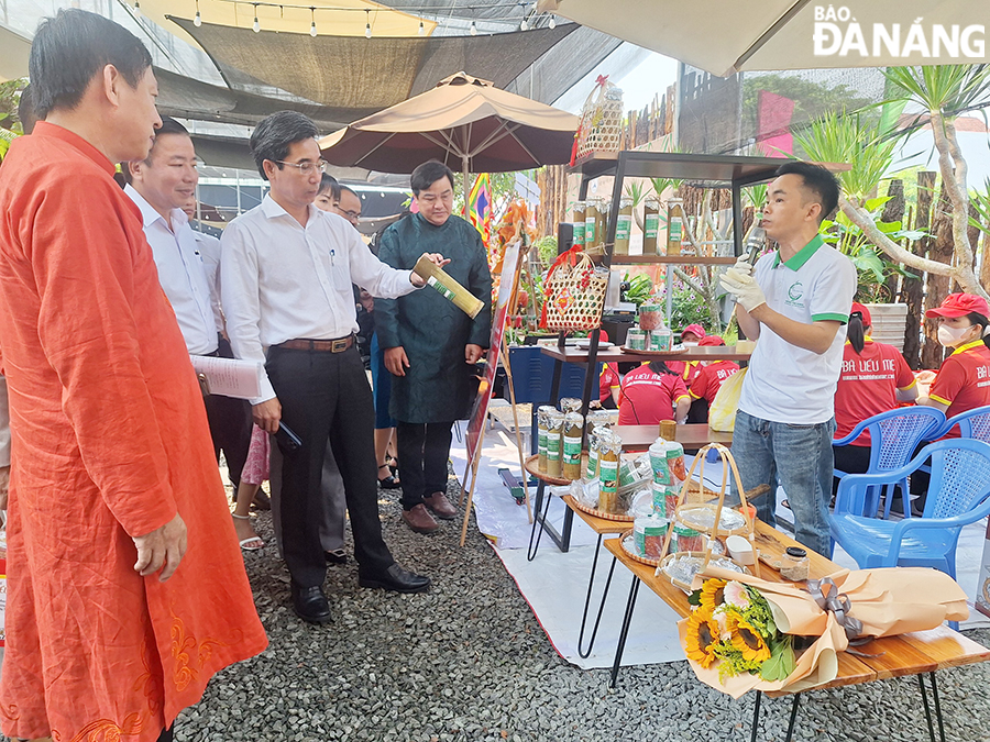  Da Nang People's Committee Vice Chairman Tran Chi Cuong (3rd, left) visits the  pork rolls wrapped in bamboo tubes. Photo: THU HA