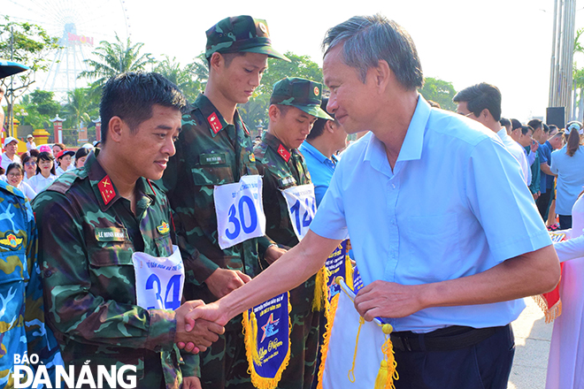 Head of the Party Committee's Publicity and Training Department Doan Ngoc Hung Anh presenting souvenir flags to participating delegations.