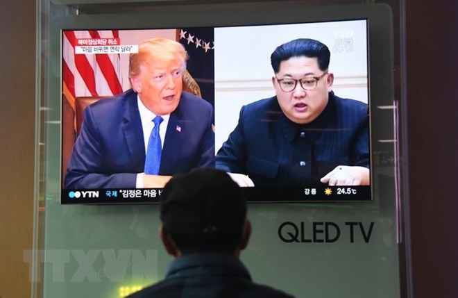 A man watches a television news screen showing US President Donald Trump (left) and DPRK leader Kim Jong Un, at a railway station in Seoul, on May 25, 2018. (Photo: AFP/VNA)