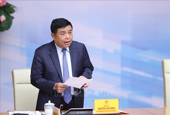 Bộ trưởng Bộ Kế hoạch và Đầu tư Nguyễn Chí Dũng báo cáo tình hình thực hiện giữ vững ổn định kinh tế vĩ mô, kiểm soát lạm phát. Ảnh: TTXVN