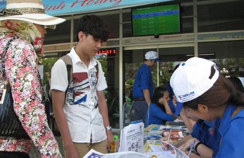 Candidate Tran Thanh Tue and his mother from Hue City receiving assistance from volunteers at the train station.