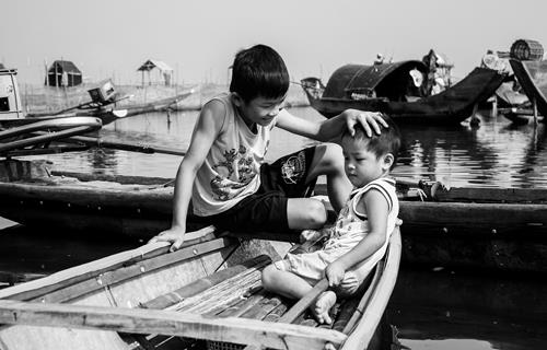  A boy taking care of his younger brother on a boat