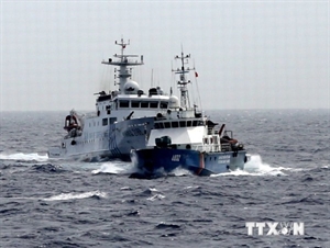 A Chinese coast guard ship (back) deliberately accelerates to hinder a Vietnamese ship (Photo: VNA)
