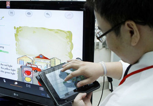 A primary student reads an e-book during English class. A new proposal would see students from first to third grade in HCM City use e-books instead of printed books this upcoming school year. 