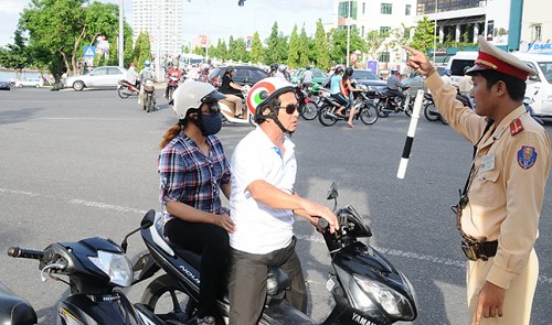 A cop at a traffic hot-spot on the western part of the Han Bridge in central Da Nang City gives guidelines to a motorcyclist.