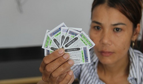 A Vinaphone subscriber poses for a photograph with the reportedly stolen prepaid cards she bought from a waste collector in Da Nang City, central Vietnam, on July 30, 2014.