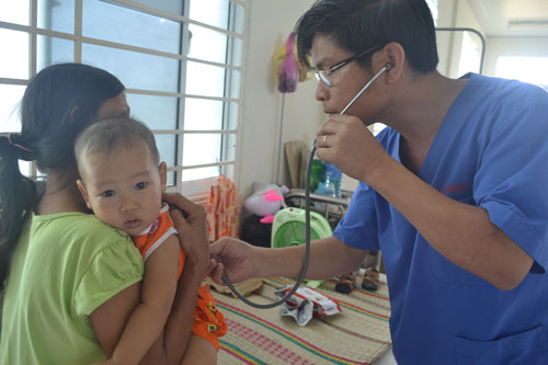 Doctor Canh examining an HFM disease-affected child