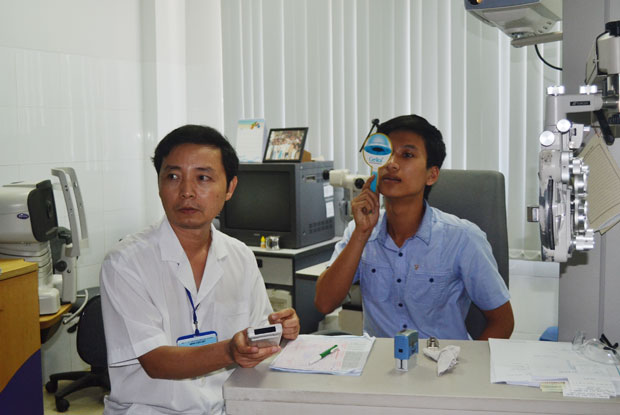 Nên đến các cơ sở có chuyên môn để đo mắt và mua kính thuốc.  Trong ảnh: BS. CKII Lương Trọng Tường đo khúc xạ cho bệnh nhân. 