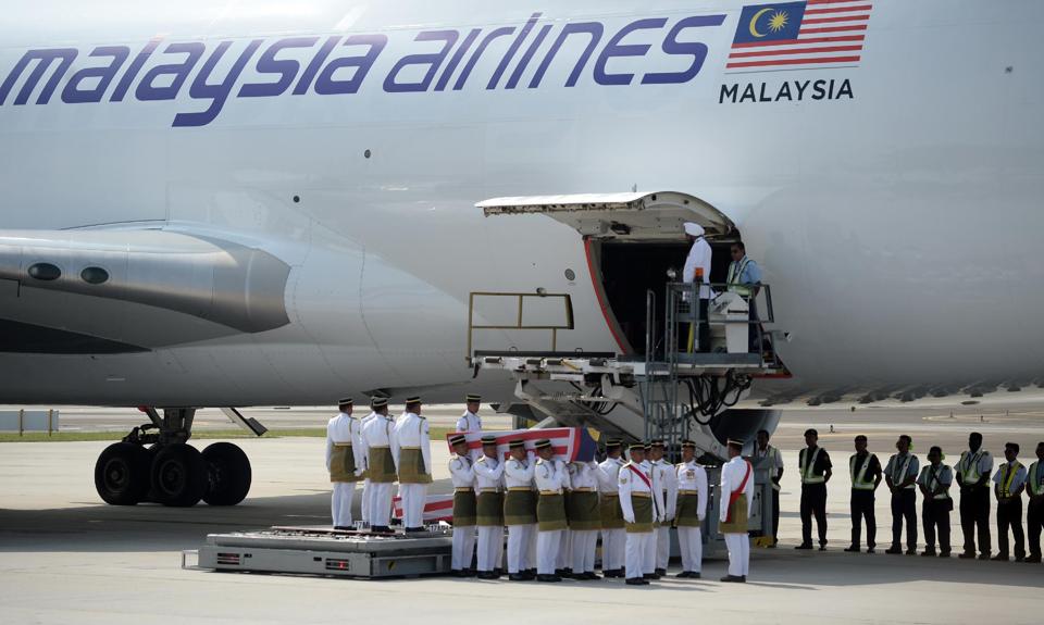 Thi thể nạn nhân MH17 đưa chuyển xuống sân bay quốc tế Kuala Lumpur, sáng ngày 22-8-2014. Ảnh: AFP