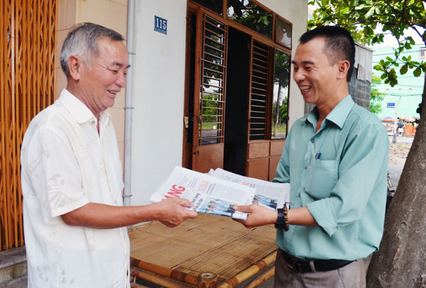 Nụ cười chào nhau khi trao và nhận tờ Báo Đà Nẵng. TRONG ẢNH: Anh Đỗ Văn Hưng, Tổ trưởng TDP 123 phường Hòa Minh đang trao báo tận nhà ông Nguyễn Văn Toản, Tổ trưởng TDP 126.Ảnh: M.T