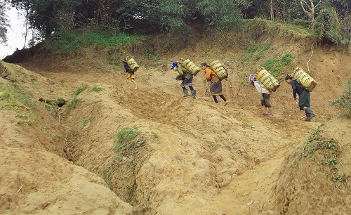 Residents of the Oi Hamlet carrying baskets of cassava on their backs