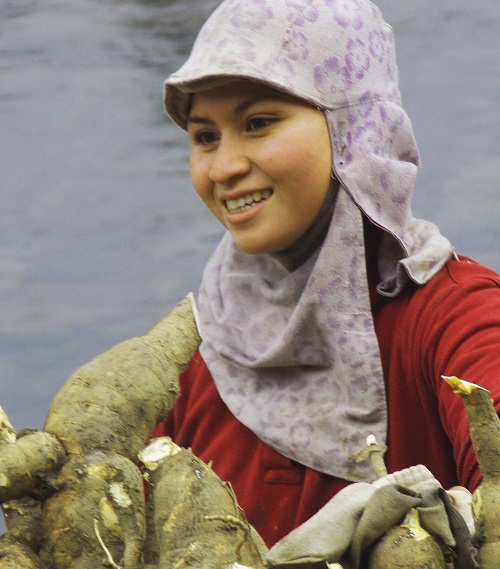 A young lady taking a short break from carrying cassava 