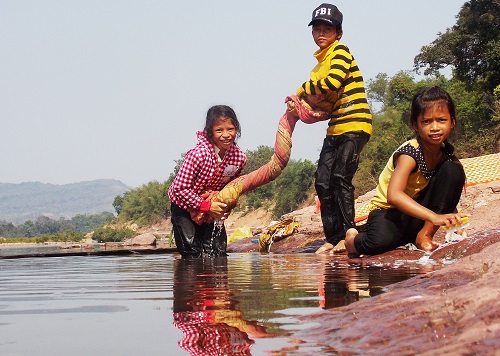    Children washing blankets on the riverbank