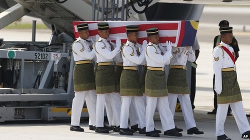 The coffins are draped in the national flag of Malaysia