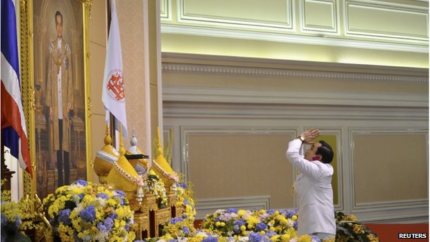 Tướng Prayuth Chan-O-Cha quỳ lạy trước chân dung lớn của Nhà vua Thái Lan, Bhumibol Adulyadej tại buổi lễ nhậm chức ngày 25-8-2014. Ảnh: Reuters