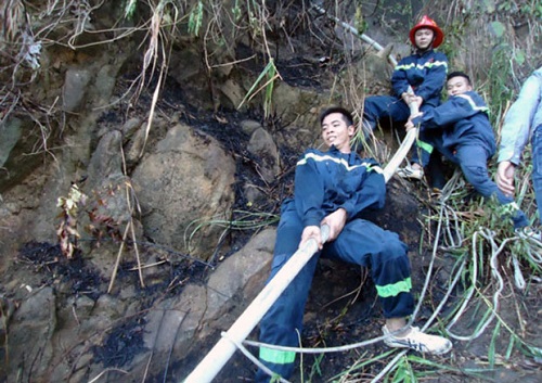 Firefighters pulling a water hose to control the fire in sub-region 4a     