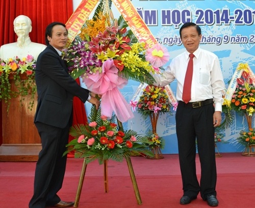 Secretary Tho presenting congratulatory flowers to the Principal of Phan Chau Trinh Senior High School