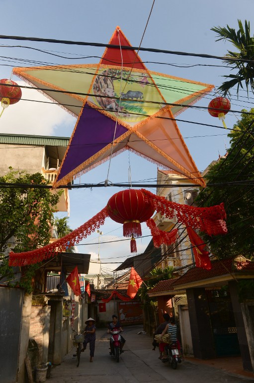 Sắc màu Trung thu len lỏi vào một ngõ nhỏ ở huyện Quốc Oai, Hà Tây, ngoại thành Hà Nội. Người dân ở đây có truyền thống trang trí đường làng ngõ xóm bằng đèn lồng đỏ và một đèn ông sao khổng lồ vào dịp rằm tháng 8. Ảnh: AFP