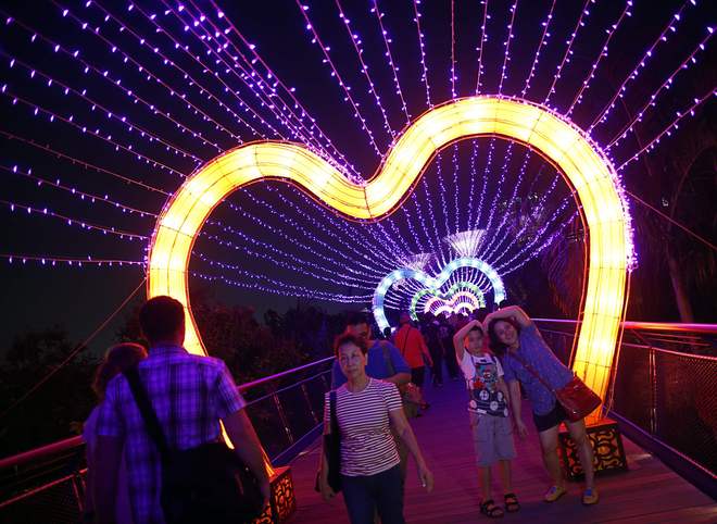 Khách tham quan tạo dáng dưới ánh đèn lung linh của lễ hội Trung thu ở Singapore. Ảnh: Reuters