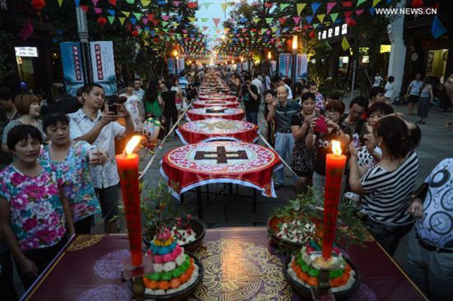 Người dân ở thành phố Hàng Châu, tỉnh Chiết Giang, Trung Quốc, chung tay làm mâm cỗ Trung thu dài trên đường phố với các loại bánh và món ăn truyền thống. Với người Trung Quốc, Trung thu là Tết Đoàn viên của gia đình. Ảnh: Xinhua
