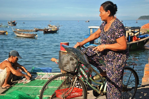     A woman has just bought a large fish from a trader