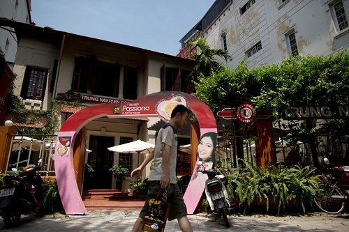 A man walks past a Trung Nguyen Corp. coffee store in Ha Noi, Viet Nam, on Saturday, May 31, 2014