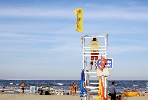 A lifeguard watching over local swimmers from a tower ready for any emergency.