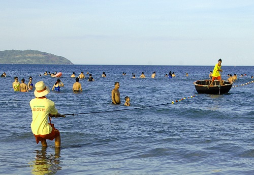  Two of the team members stretching rope floats to identify the safe-swimming area …