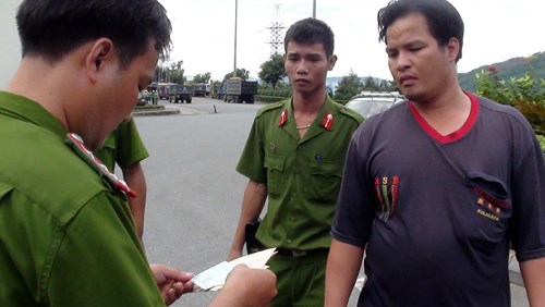 Da Nang police check papers produced by Tran Van Nam, the driver of the truck.