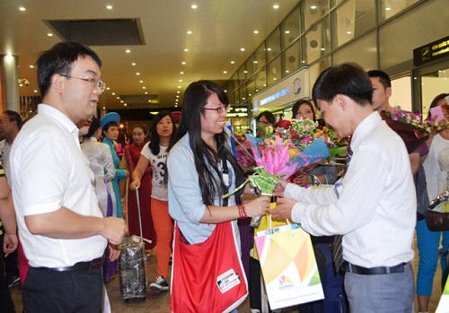  Presenting flowers to the first passengers off the flight