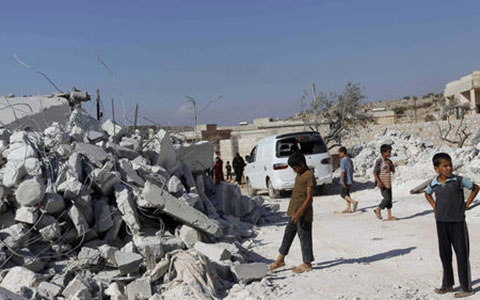 Một khu dân cư bị máy bay liên quân không kích ở Syria (Ảnh Reuters)